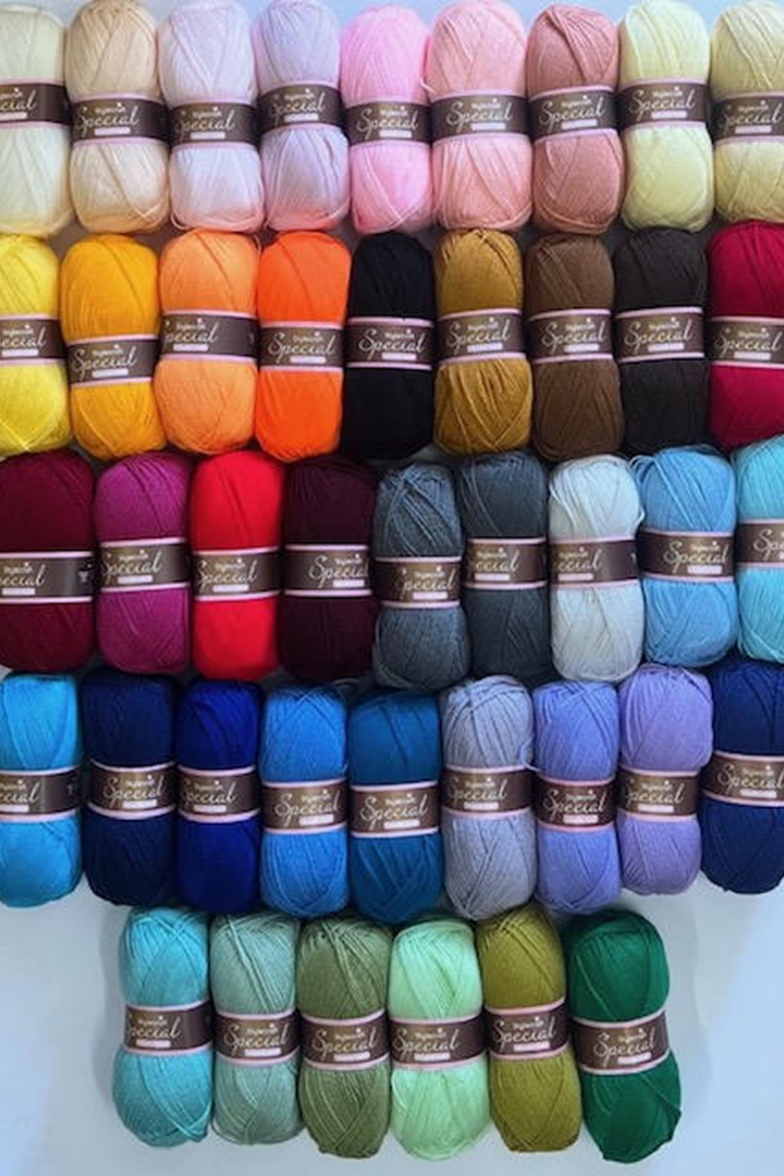 Multicolored yarn collection displayed on shelves.